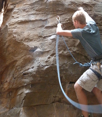 photo of sport climber clipping rope through a carabiner